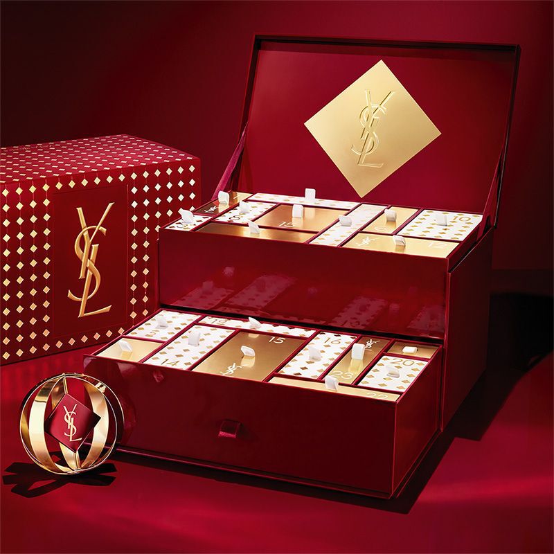 Calendrier de l’Avent beaute YSL avec des cosmetiques et des parfums dans un presentoir rouge et or.