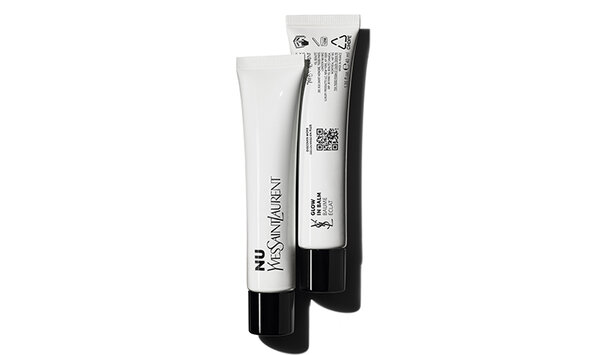 Two tubes of YSL skincare products are displayed against a white background. One tube is standing upright, while the other is tilted slightly to the side. The packaging features a sleek, modern design in black and white.