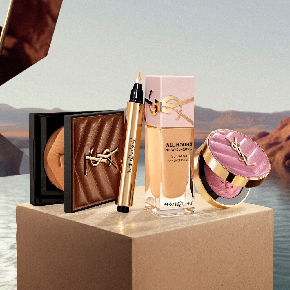 Essentiels maquillage YSL presentes sur un piedestal dans un decor inspire du desert.