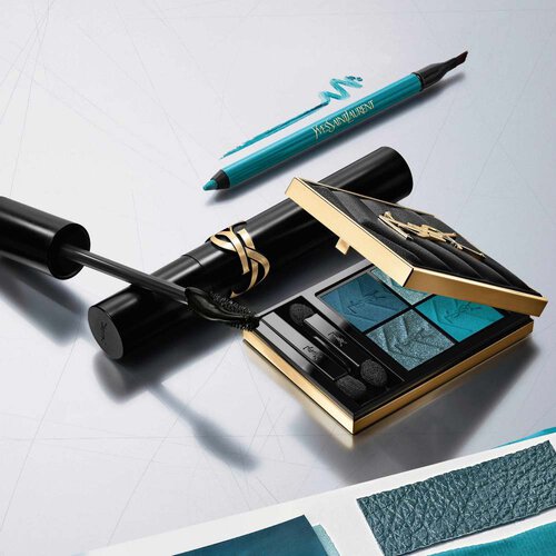 Luxus-Make-up-Kollektion von YSL: blaue Lidschattenpalette, Mascara und Eyeliner auf silbernem Hintergrund.