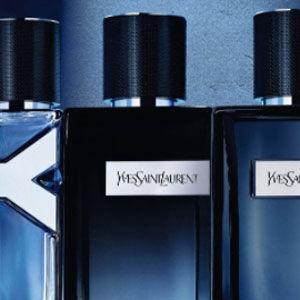Three elegant perfume bottles from Yves Saint Laurent displayed against a blue background, each featuring a sleek design and distinctive labels.