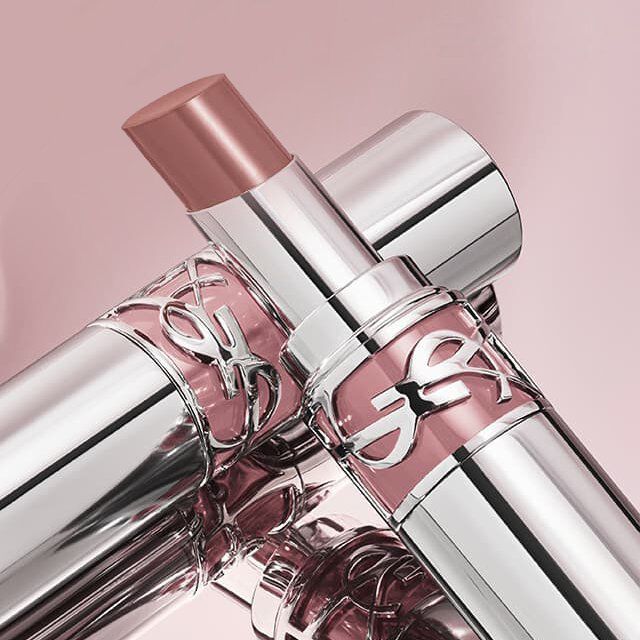 Zwei YSL Lippenstifte in Silber und Rosa, einer offen mit Nude-Farbton.