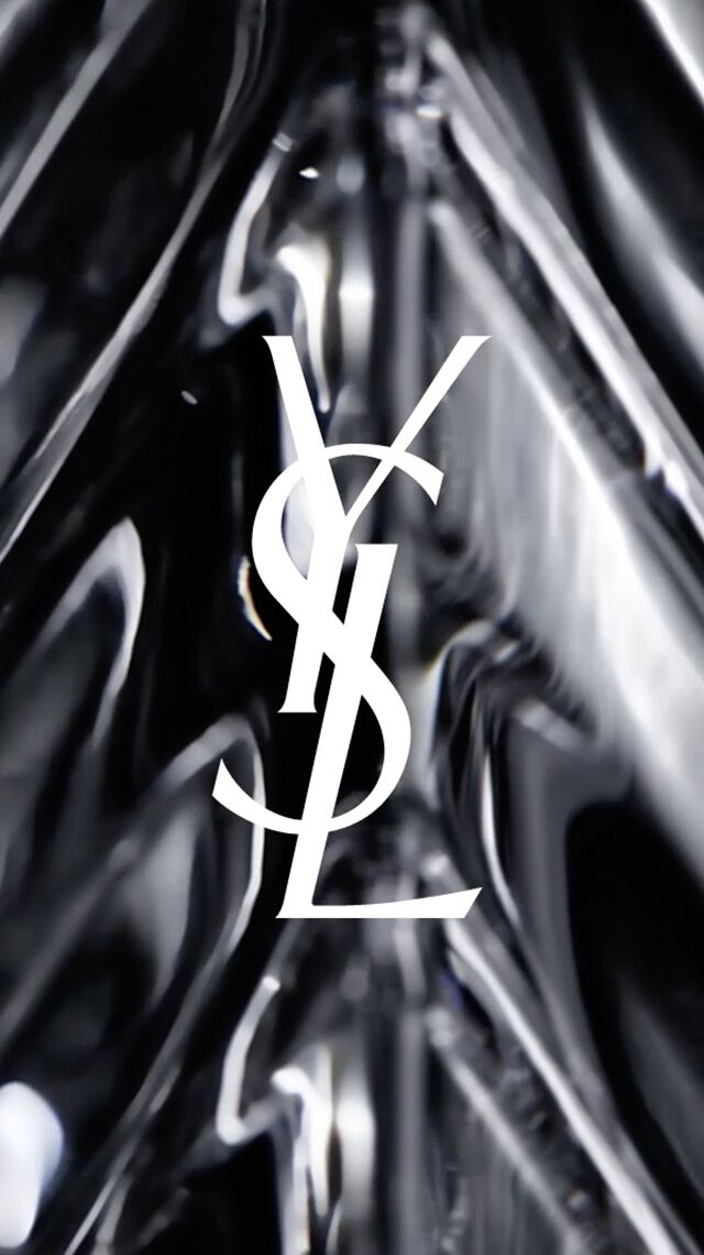 Weißes YSL-Logo auf schwarzem, facettiertem Glashintergrund.