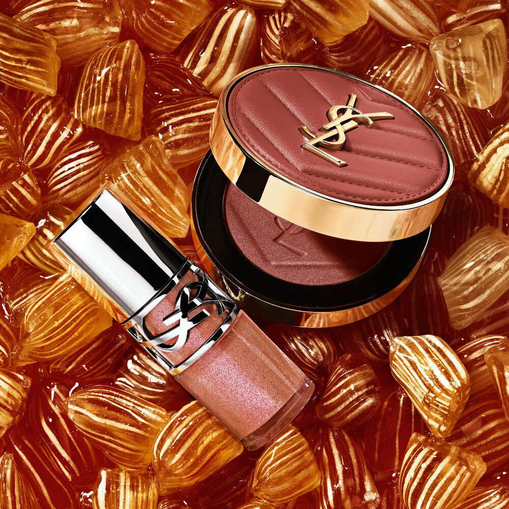 YSL LOVESHINE Plumping Lip Oil Gloss Farbton 12 und Make Me Blush Farbton 12, eingebettet in goldene Berlingot-Bonbons.