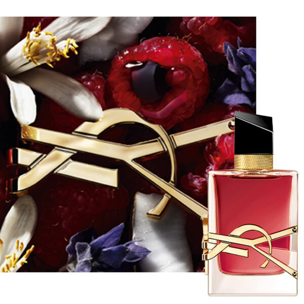 Gros plan du flacon Libre Berry Crush, orne du logo YSL dore, entoure de baies rouges et d’elements floraux.