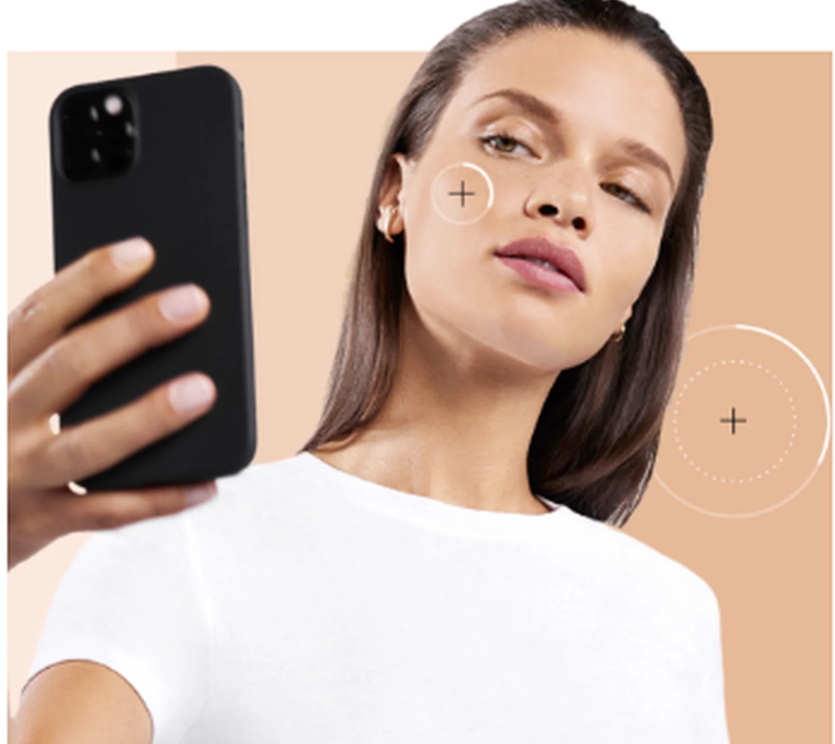 A woman with long brown hair takes a selfie with a smartphone, showcasing a neutral expression. The background features a gradient of skin tone colors.