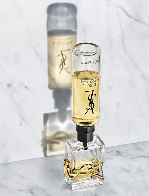 Ein eleganter Flakon mit Parfum auf einer marmorierten Oberflache, der das YSL-Logo zeigt.
