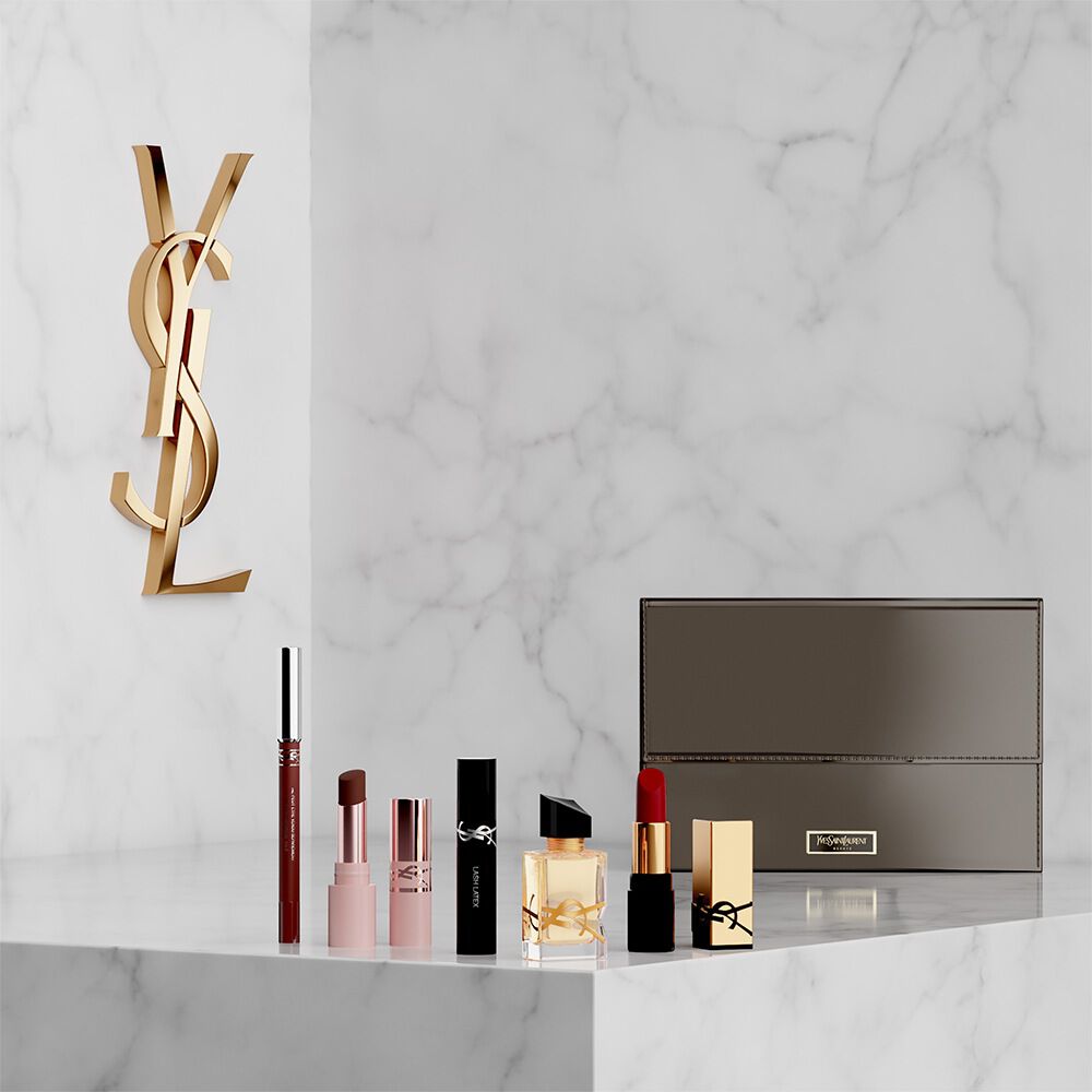 YSL Beauty-Set mit Miniprodukten und weißer Kosmetiktasche.