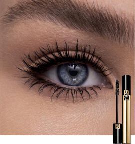 Close-up of a blue eye with long, defined eyelashes, alongside a tube of mascara.