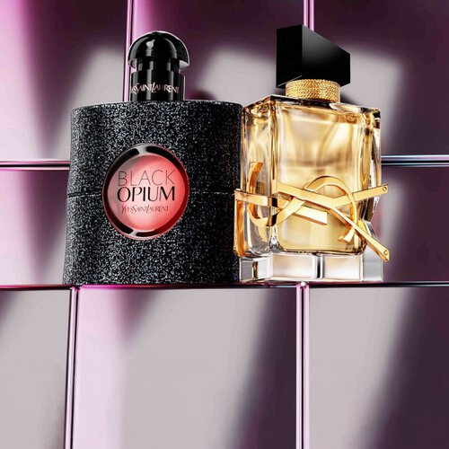 Produits de beaute YSL comprenant un boitier matelasse, un mascara et deux rouges a levres sur fond de carrelage rose brillant.