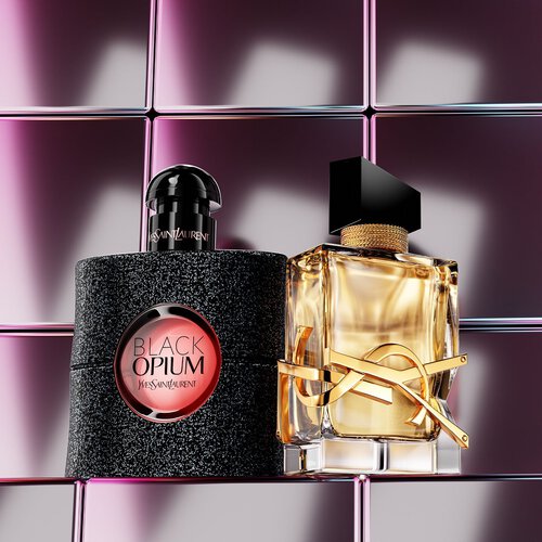 YSL-Duftflakons auf einem Podest vor einer Wustenlandschaft.