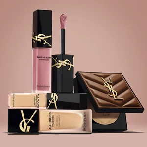YSL-Beauty-Produkte mit Rouge, Foundation und Kompaktpuder vor nudefarbenem Hintergrund.