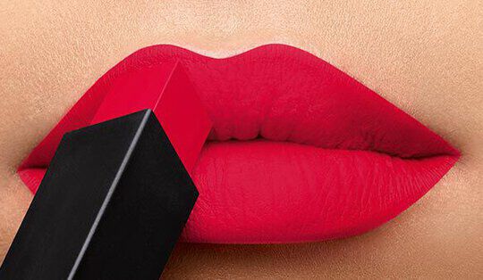 Close-up of bold red lips with a lipstick bullet being applied.