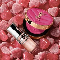 YSL Make Me Blush Powder Blush and LOVESHINE Plumping Lip Oil Gloss in shade 10, nestled among pink heart-shaped candie.
