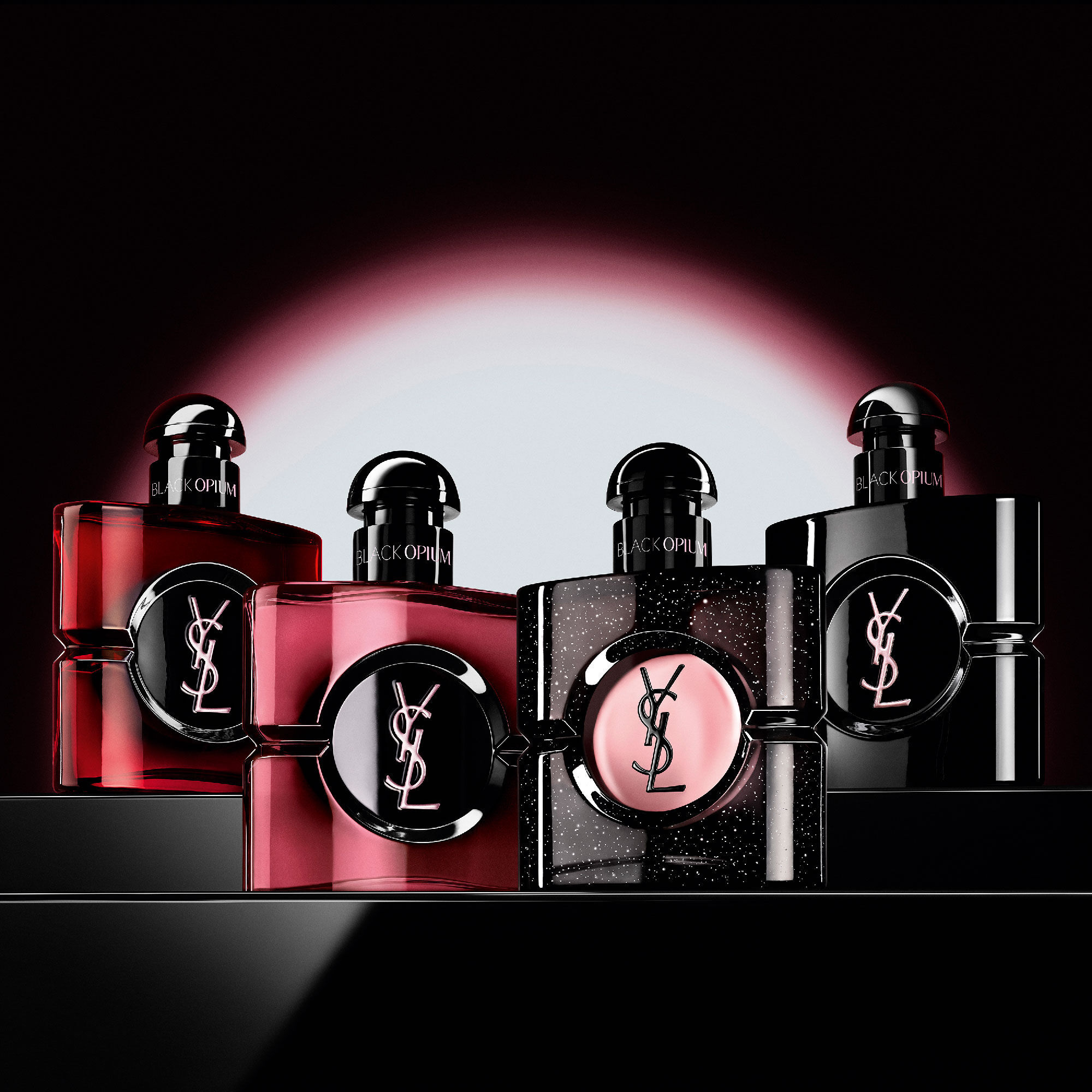 Vier verschiedene Black Opium Parfumflakons in einer Reihe
                        auf einer dunklen, reflektierenden Oberflache.