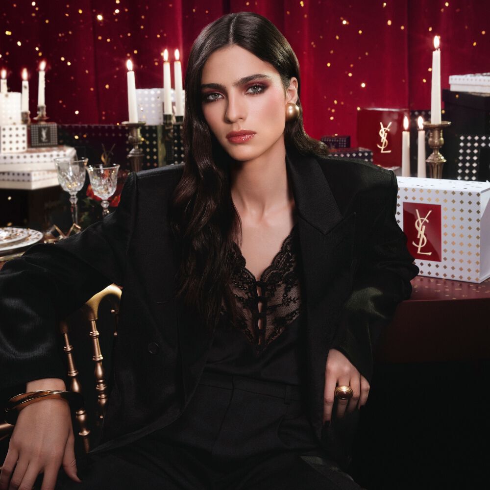 Modell in schwarzem Anzug und glamourosem Look, sitzend in festlicher, von Kerzenlicht durchfluteter Atmosphare mit YSL-Geschenkboxen. Modell in schwarzem Anzug und glamourosem Look, sitzend in festlicher, von Kerzenlicht durchfluteter Atmosphare mit YSL-Geschenkboxen. Modell in schwarzem Anzug und glamourosem Look, sitzend in festlicher, von Kerzenlicht durchfluteter Atmosphare mit YSL-Geschenkboxen. B7 Banner versteckt