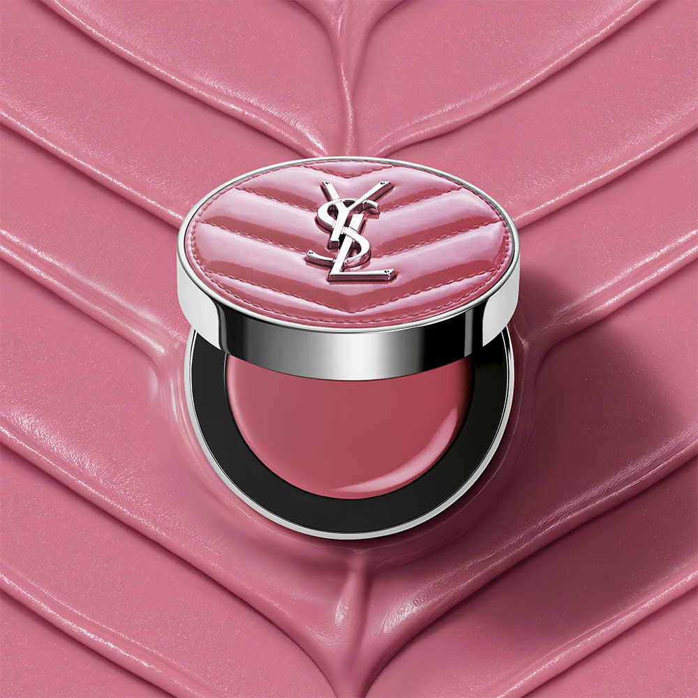 Un boitier ouvert de YSL Make Me Blush Lifted Glow Cream Blush, teinte #44 Nude Lavalliere, sur un fond creme texture rose assorti.
