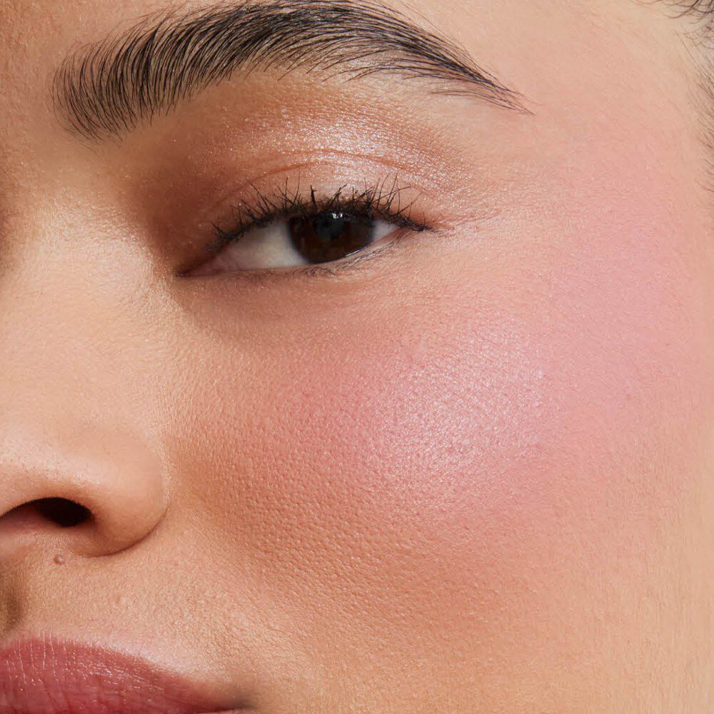 Gros plan sur la joue d’un modèle révélant le fini mat soft-focus et airbrushé de Make Me Blush Powder, teinte #44, pour un flush de couleur modulable et un effet flouté.