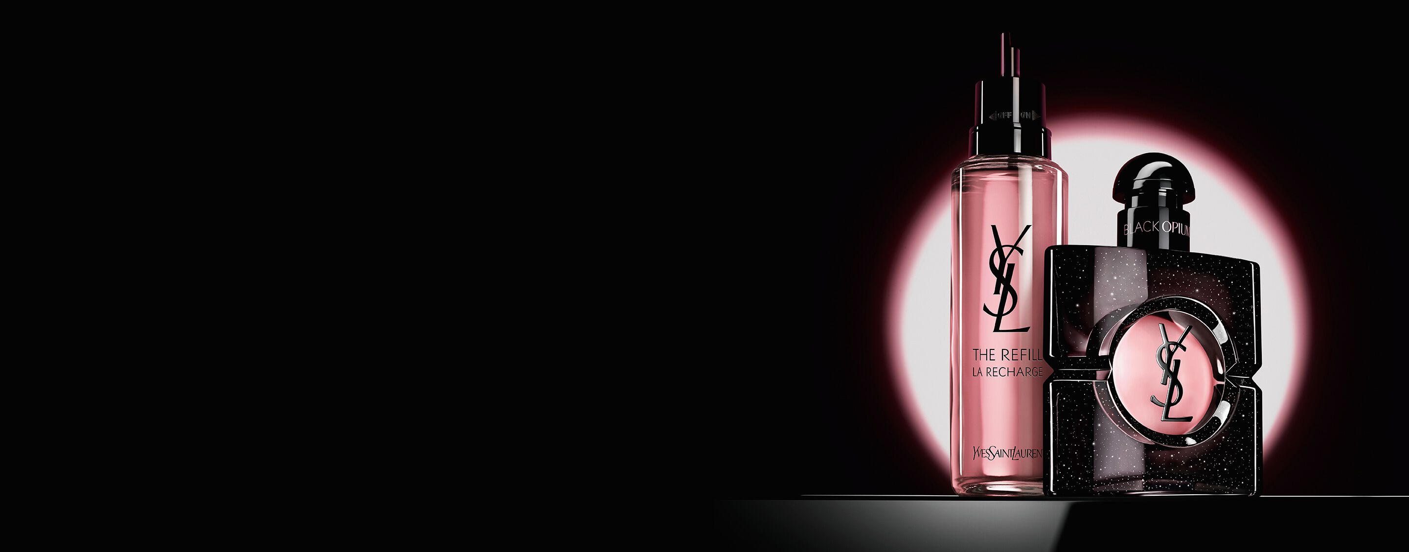 Flacon de Black Opium Eau de Parfum présenté à côté de sa recharge en verre de 100 ml ornée du logo YSL.