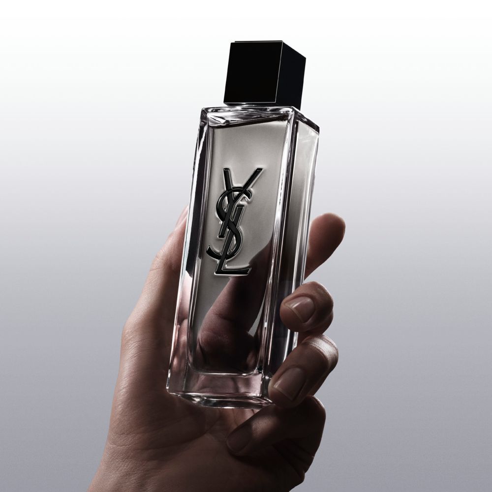 Eine Hand hält den Flakon von MYSLF Eau de Toilette Intense, um seine Form und sein Design zu zeigen.