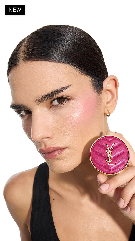 Iman, mittlere Haut, hält das fuchsiafarbene YSL Make Me Blush Puder-Rouge in Nuance 66.