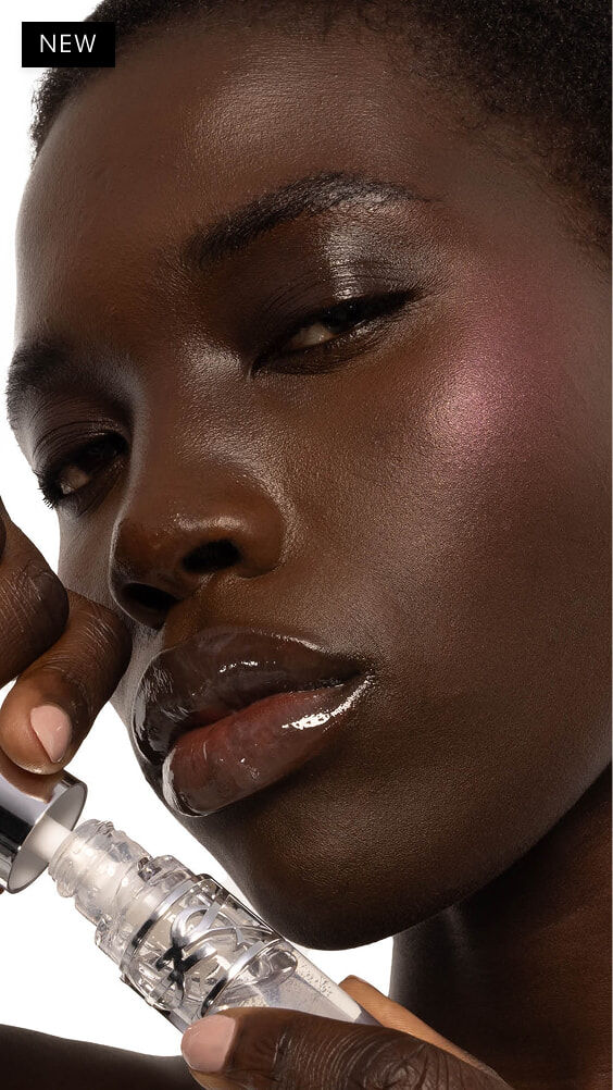 Nyaluak, dunkle Haut, mit YSL LOVESHINE Plumping Lip Oil Gloss in Nuance 11 Radiant Glass.