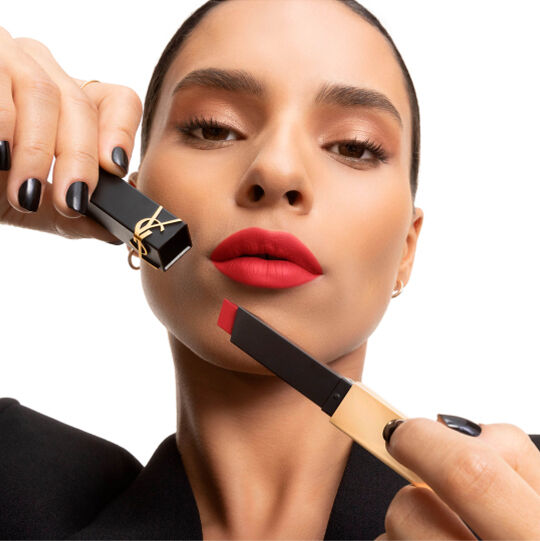 Main présentant un rouge à lèvres YSL carré rose doux près de la joue.