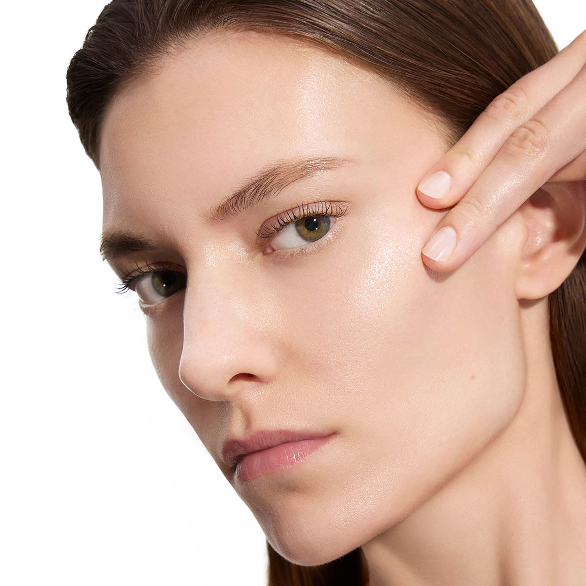 Marije, Modell für YSL Beauty, mit heller Haut, berührt sanft ihre Wange und zeigt glatte Haut nach der Anwendung der Lotion.