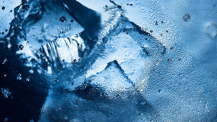 Gros plan sur de la glace et des gouttelettes d'eau, évoquant la fraîcheur intense et glaciale de YSL Y Eau de Toilette Intense Iced Cologne.