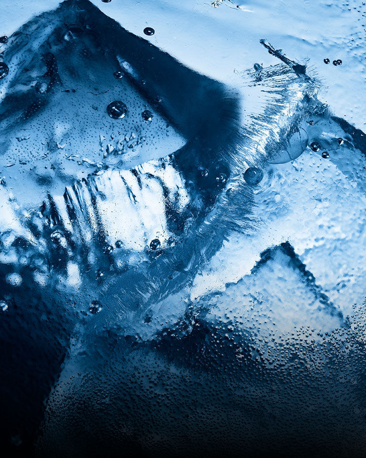 Gros plan sur de la glace et des gouttelettes d'eau, évoquant la fraîcheur intense et glaciale de YSL Y Eau de Toilette Intense Iced Cologne.