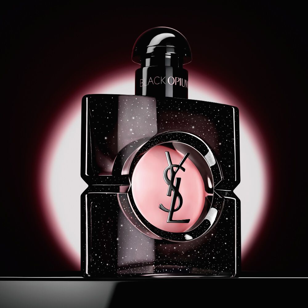 Flacon Black Opium Eau de Parfum sublimé par un halo circulaire rose sur fond sombre.