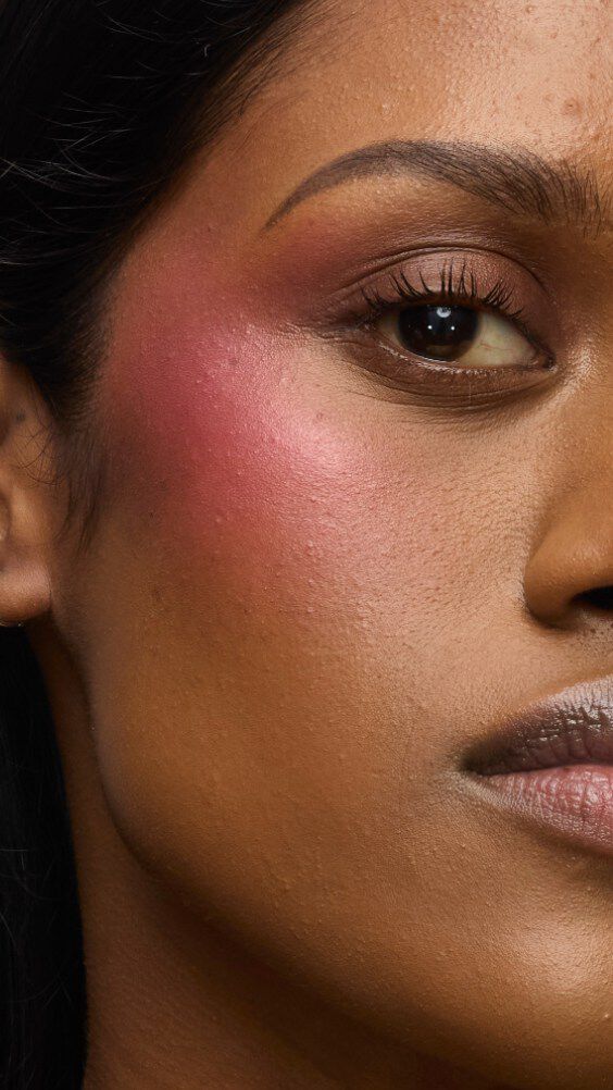 Gros plan sur la joue d’un modèle portant la routine Make Me Blush : Poudre #66 Fuchsia Fizz superposée à la Crème #86 Raspberry Glaze pour un fini juteux et vibrant.